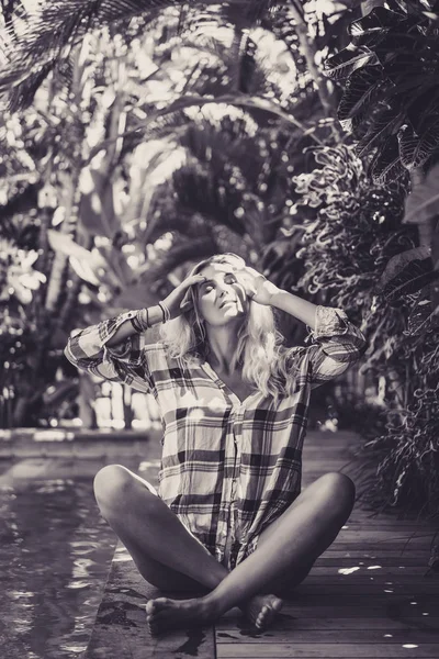 Молодая женщина сидит у бассейна — стоковое фото