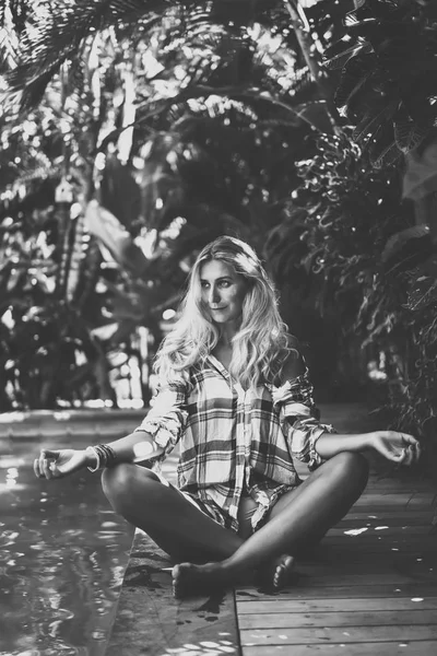 Junge Frau sitzt in der Nähe des Pools — Stockfoto