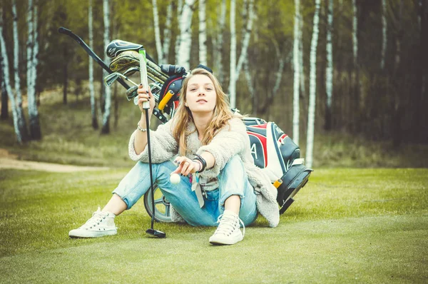 Mladá žena s golfové kluby — Stock fotografie