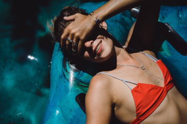 Kadın kırmızı bikini şişme yuvarlağına yalan