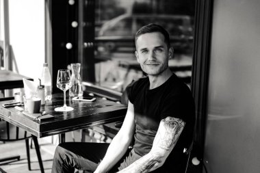 yaz terasında oturan dövmeli adam