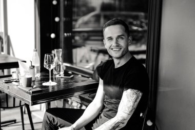 yaz terasında oturan dövmeli adam