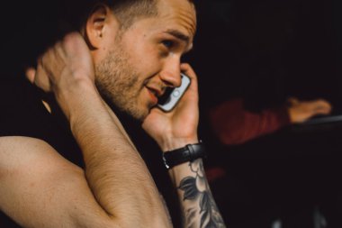 Dövmeli adam telefonda konuşurken