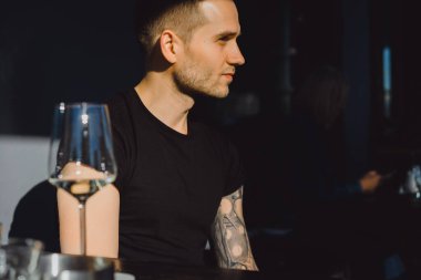 yaz terasında oturan dövmeli adam