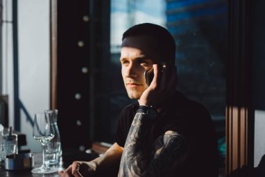 Dövmeli adam telefonda konuşurken