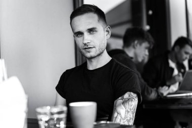 yaz terasında oturan dövmeli adam