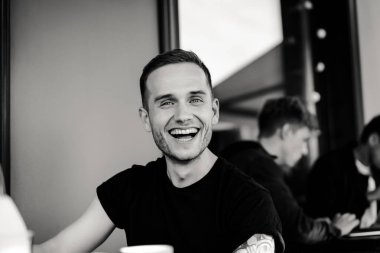 yaz terasında oturan dövmeli adam