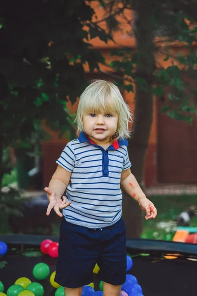 Niño saltando en trampolín con bolas de colores —  Fotos de Stock