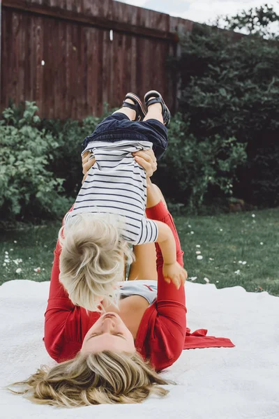 Madre divirtiéndose con su hijo en manta — Foto de Stock