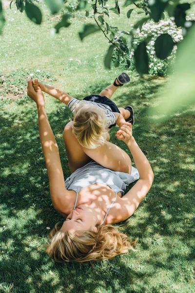 Mãe se divertindo com seu filho na grama — Fotografia de Stock