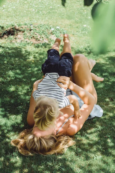 Mutter amüsiert sich mit ihrem Sohn im Gras — Stockfoto