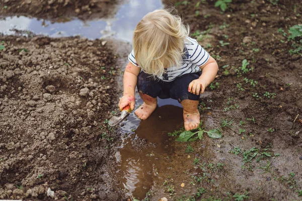 Niño jugando con la pala en el jardín — Foto de Stock