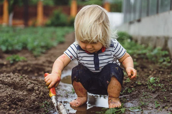 Menino brincando com pá no jardim — Fotografia de Stock