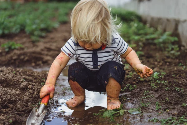 Menino brincando com pá no jardim — Fotografia de Stock