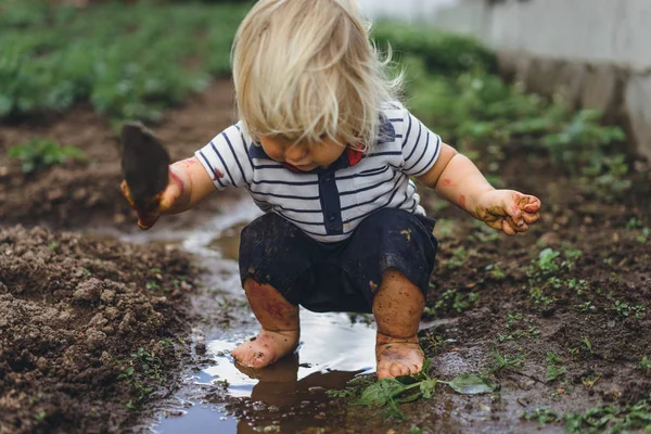 Menino brincando com pá no jardim — Fotografia de Stock