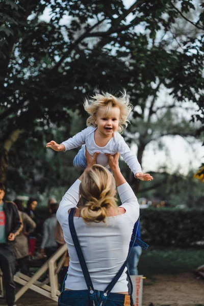 Woman throwing up son outdoors — Stock Photo, Image