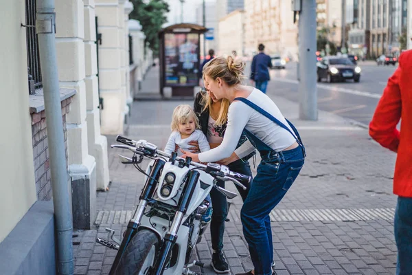 Kvinnor ha kul med barn pojke på motorcykel — Stockfoto