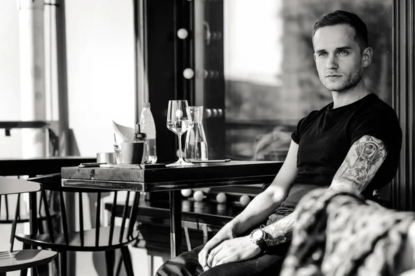 Tätowierter Mann sitzt auf Sommerterrasse — Stockfoto