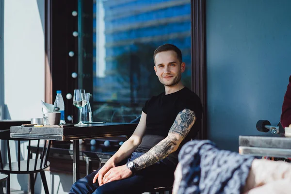 Hombre tatuado sentado en la terraza de verano — Foto de Stock