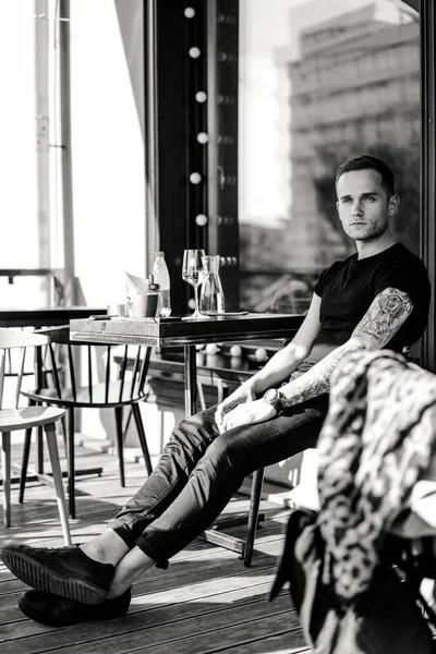 Hombre tatuado sentado en la terraza de verano —  Fotos de Stock