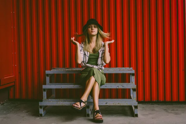 Mädchen mit Hut sitzt auf Holztreppe — Stockfoto