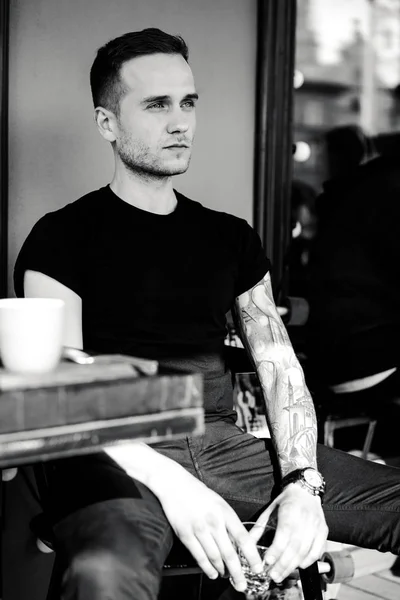 Hombre tatuado sentado en la terraza de verano — Foto de Stock