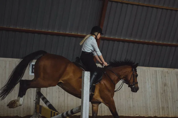 Meisje op paard door de hindernis springen — Stockfoto