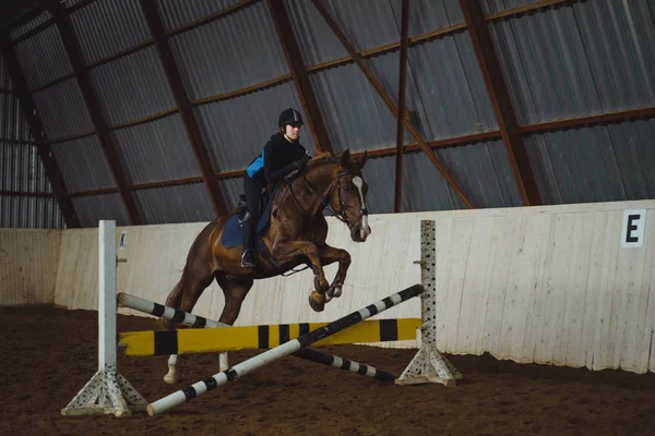 Chica saltar en caballo a través de obstáculo — Foto de Stock