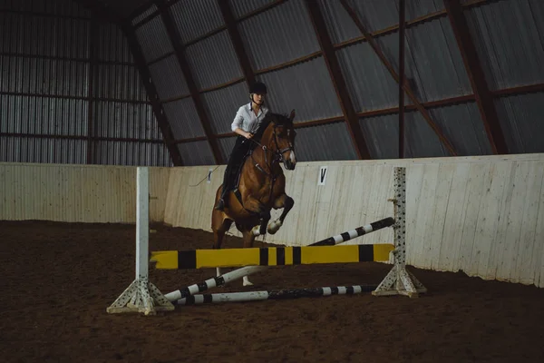 Chica saltar en caballo a través de obstáculo — Foto de Stock