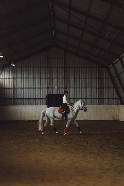 Vrouw paardrijden paard in arena — Stockfoto