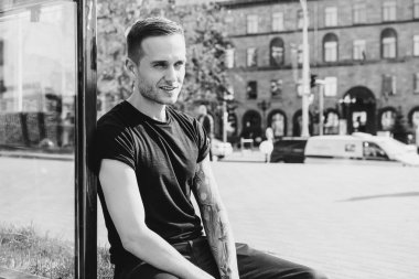 yaz terasında oturan dövmeli adam