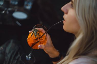 Kadın kokteyl içiyor.