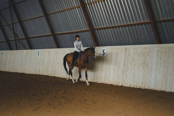 Vrouw paardrijden paard in arena — Stockfoto