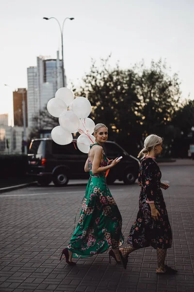 Frauen in Kleidern gehen mit Luftballons — Stockfoto