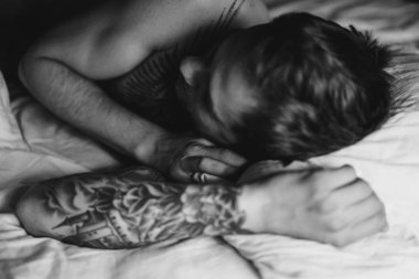 yatakta yastık üzerinde yatan adam