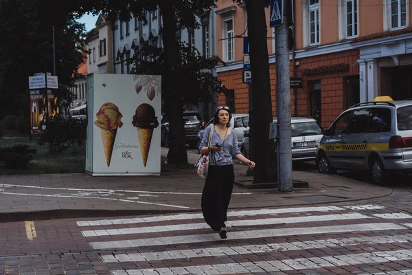 Mulher cruzando calçada na rua da cidade — Fotografia de Stock