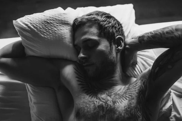 Tattooed man sleeping on bed — Stock Photo, Image