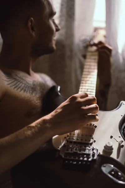 Homme jouant de la guitare à la maison — Photo