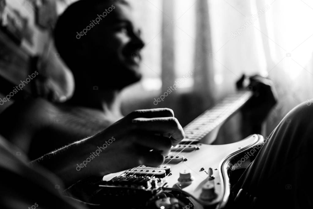 man playing guitar at home