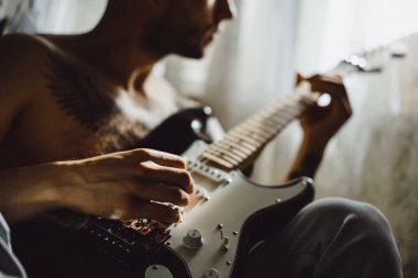 Evde gitar çalan adam.