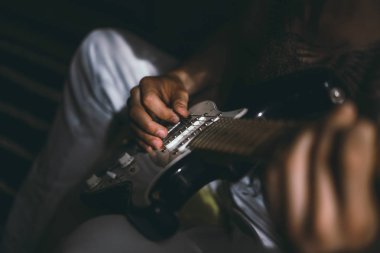 Evde gitar çalan adam.