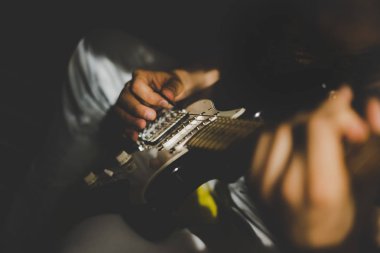 Evde gitar çalan adam.