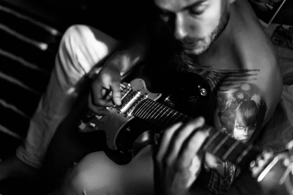 Hombre tocando la guitarra en casa — Foto de Stock