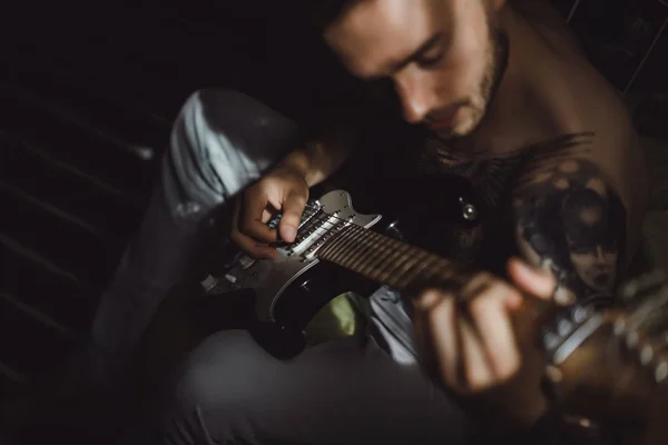 Мужчина играет на гитаре дома — стоковое фото