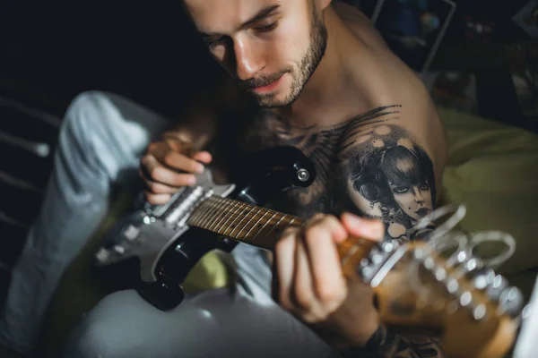 Uomo che suona la chitarra a casa — Foto Stock