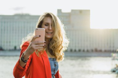 Telefonunuzun ve açık kırmızı ceketli sarışın genç kadın