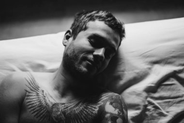 Yatakta dövmeli adam 