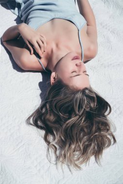 sevimli sarışın kadın beyaz yorgan yaz açık mavi elbiseli