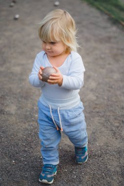 sevimli sarışın çocuk topu açık tutan mavi giysili 