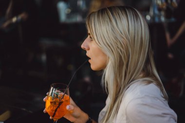 Kadın kokteyl içiyor.